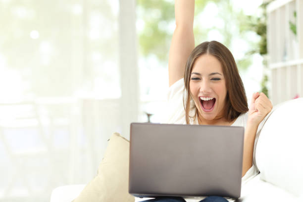 Excited girl enjoying cheap high speed internet sitting on a couch at home