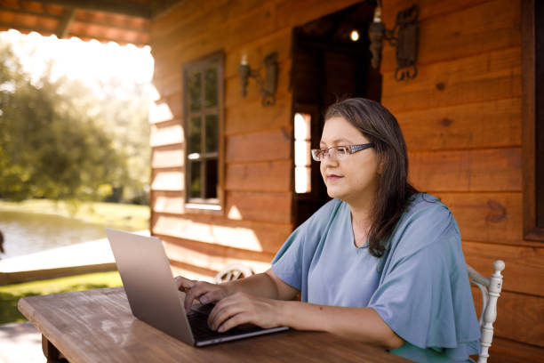 women working on her laptop in rural area